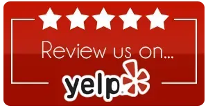 Red sign with five stars and text “Review us on Yelp”