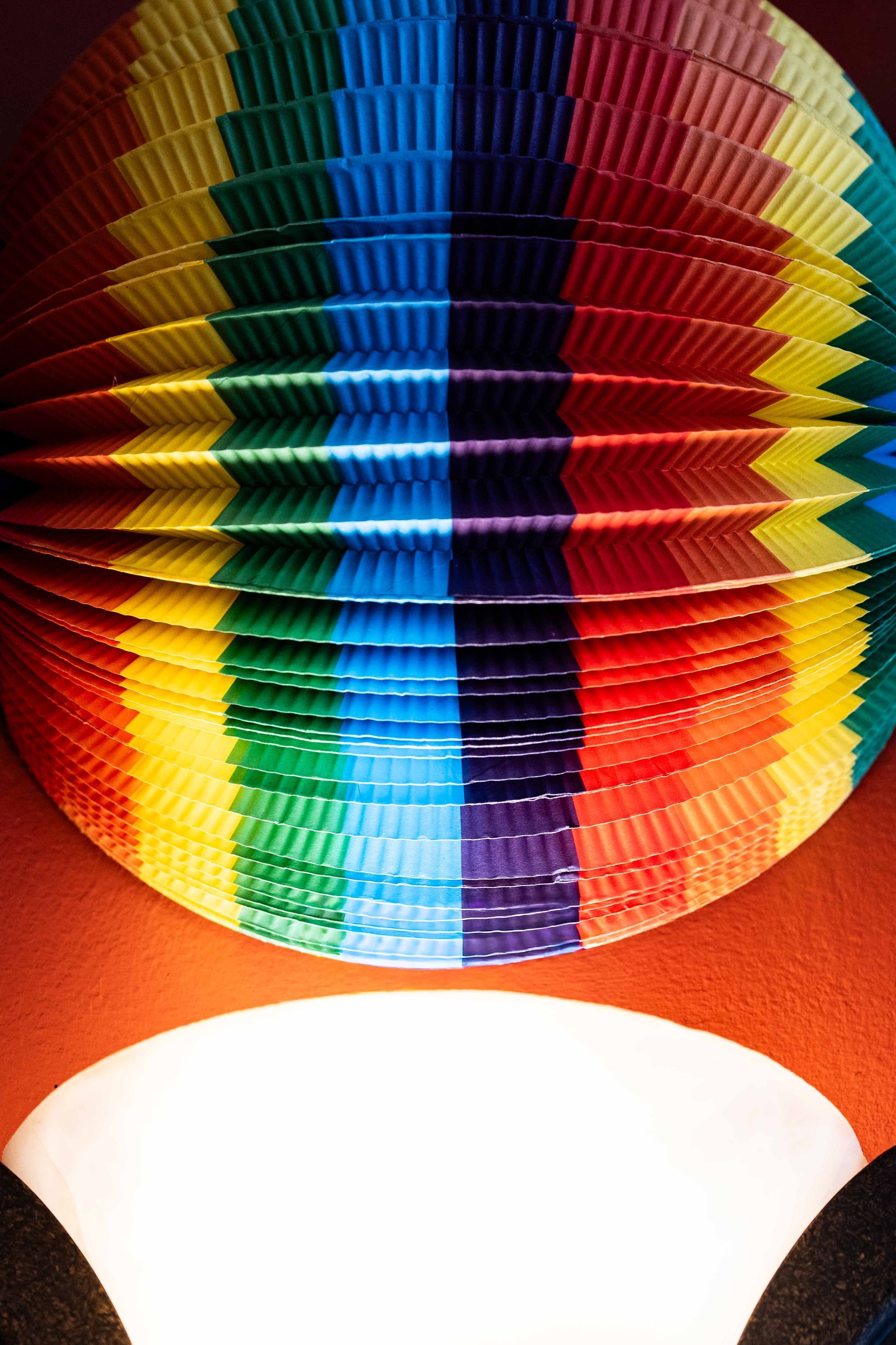 Colorful striped hanging lantern glowing above a bright white light