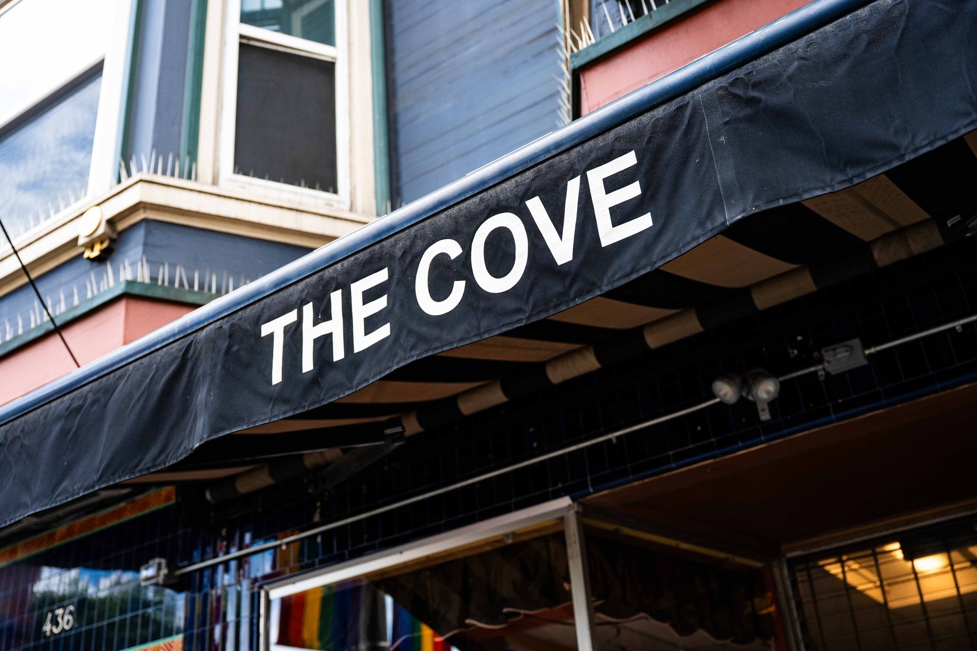 Black awning reading “THE COVE” on a storefront with windows above