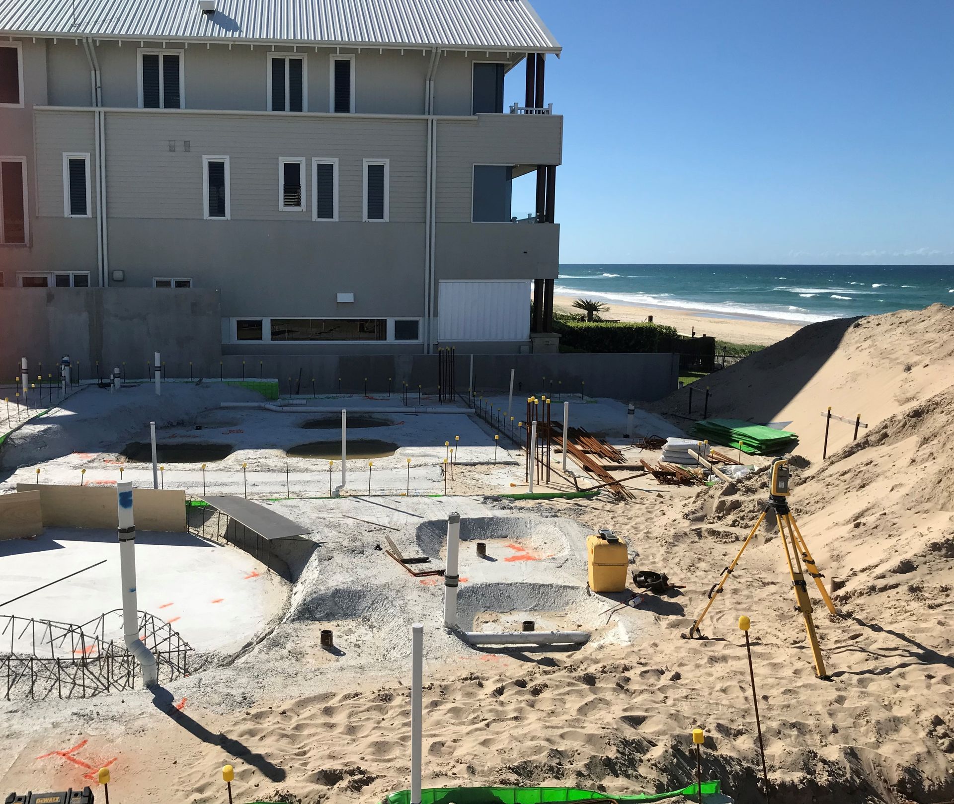 A construction site with a house in the background and a beach in the background