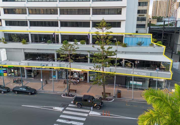 A car is driving down a street in front of a building.