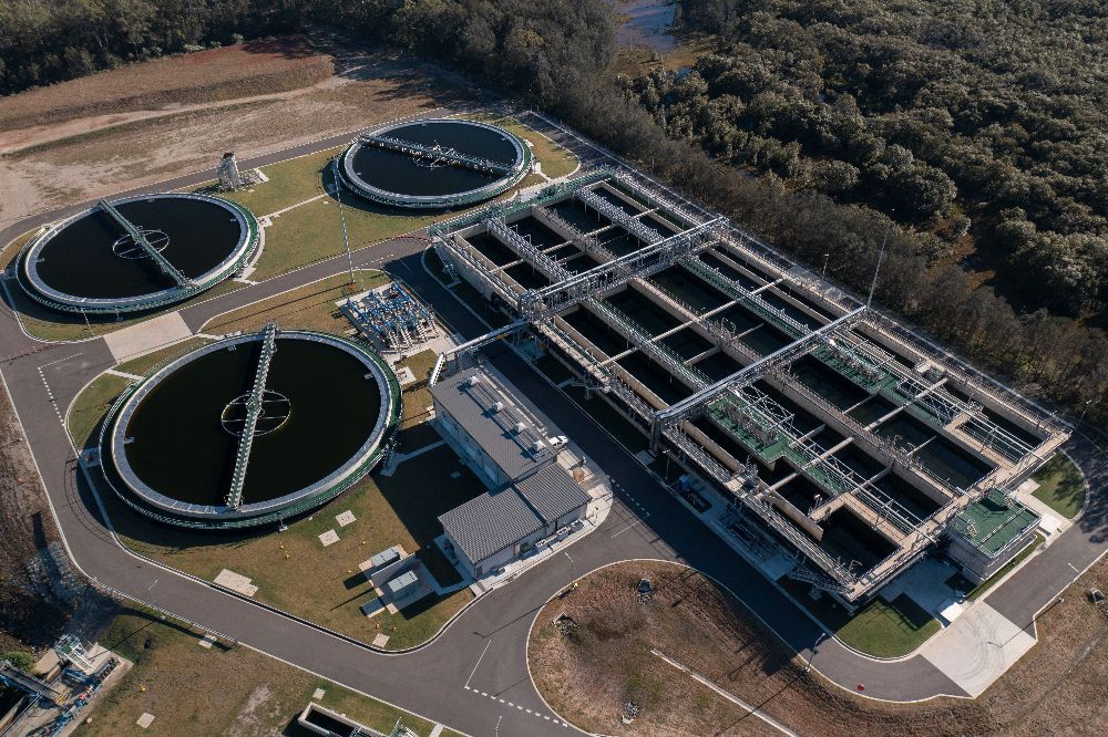 An aerial view of a large water treatment plant surrounded by trees.