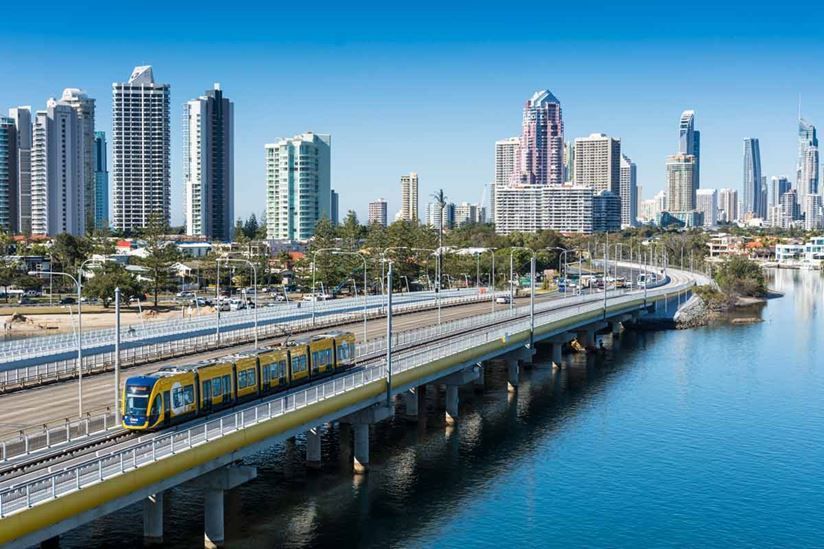 A train is going over a bridge over a body of water.