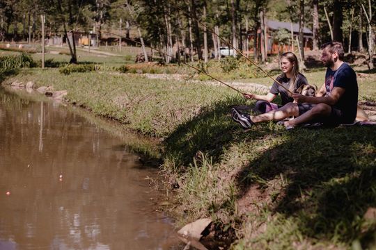 Um homem e uma mulher estão pescando em um lago.