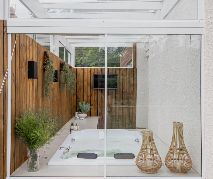 Uma casa de banho com banheira jacuzzi e porta de correr em vidro.