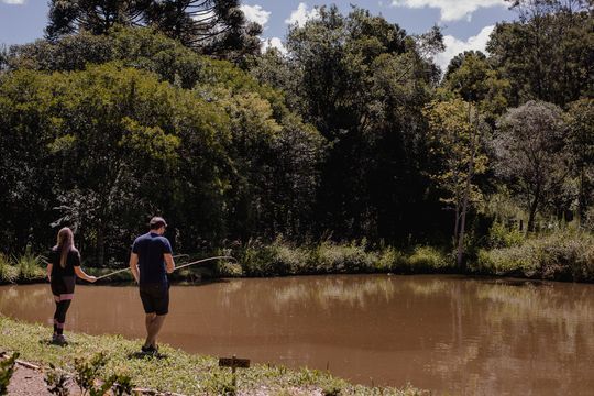 Um homem e uma mulher estão pescando em um lago.