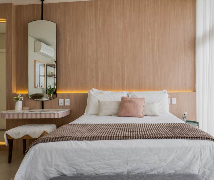 Um quarto com uma cama grande e um espelho na parede.