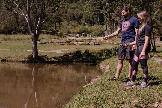 Um homem e uma mulher estão pescando em um lago.