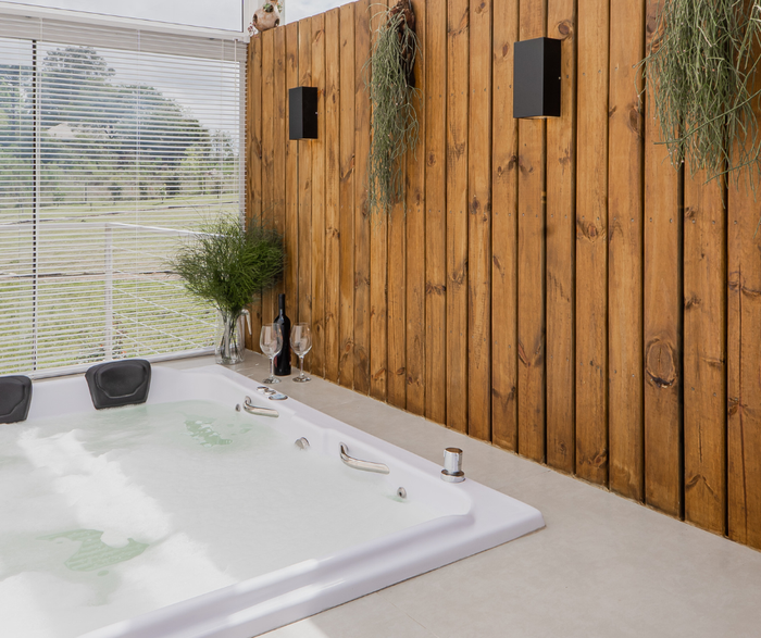 Há uma banheira jacuzzi no meio da sala.