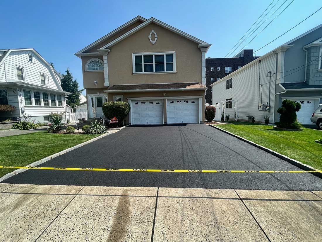 Suburban house with a double garage and long driveway, viewed from the street
