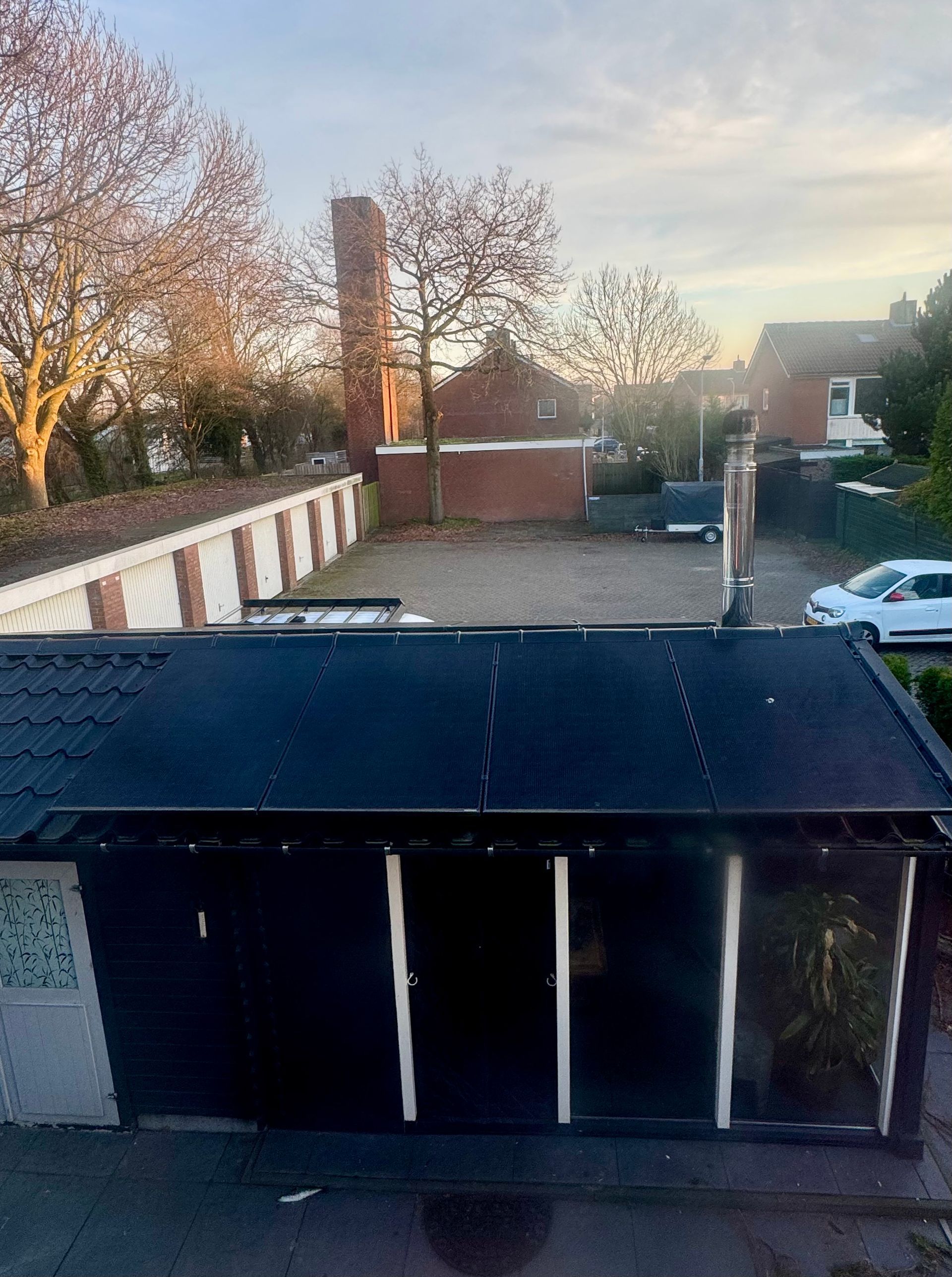Een laadpaal voor elektrische voertuigen op een bakstenen muur met een bordje. Het nummer 24 is erboven zichtbaar.