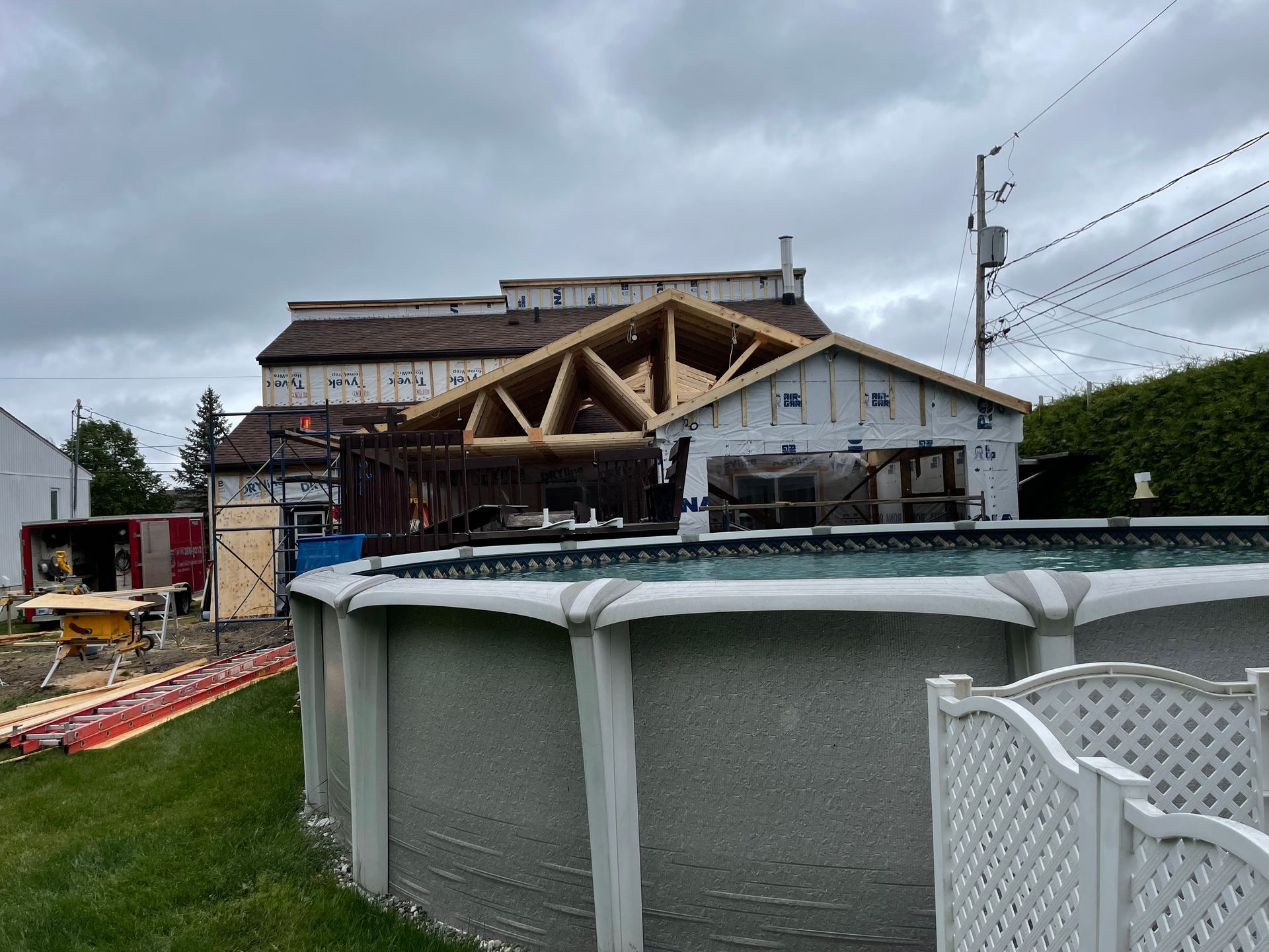 Une piscine est installée devant une maison en construction.