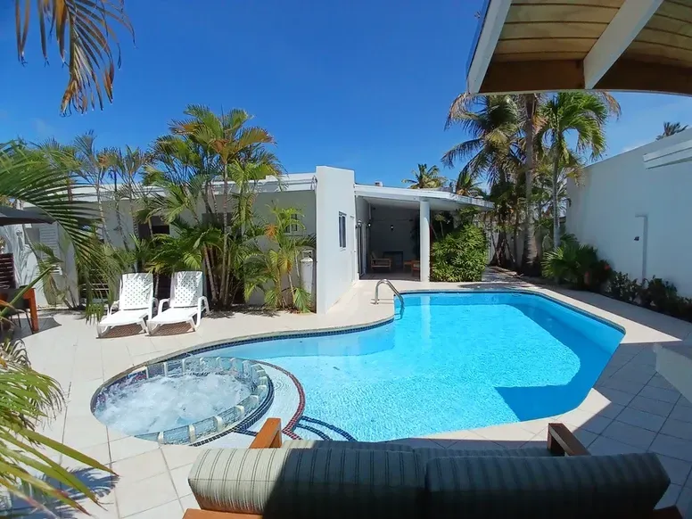A large swimming pool with a hot tub in the middle