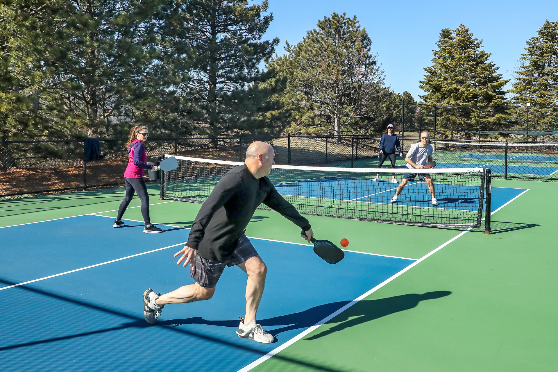 A group of people are playing tennis on a court.