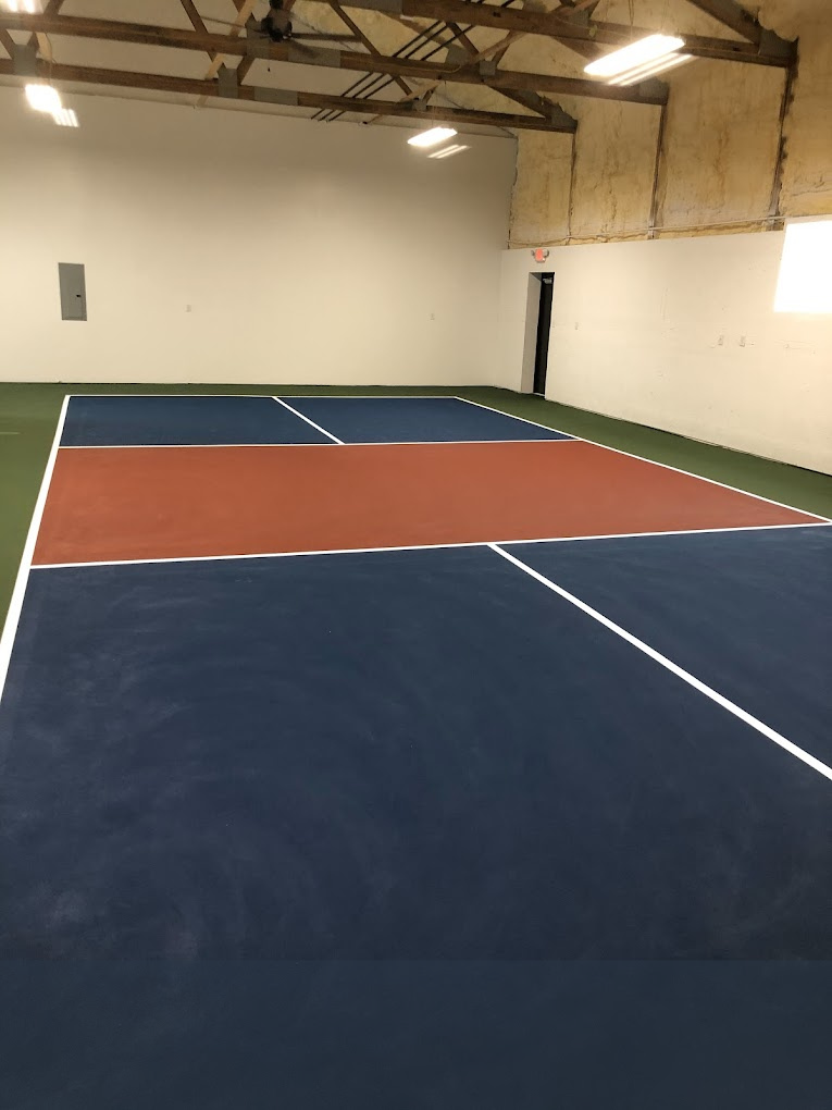 an indoor pickleball court with blue and red lines
