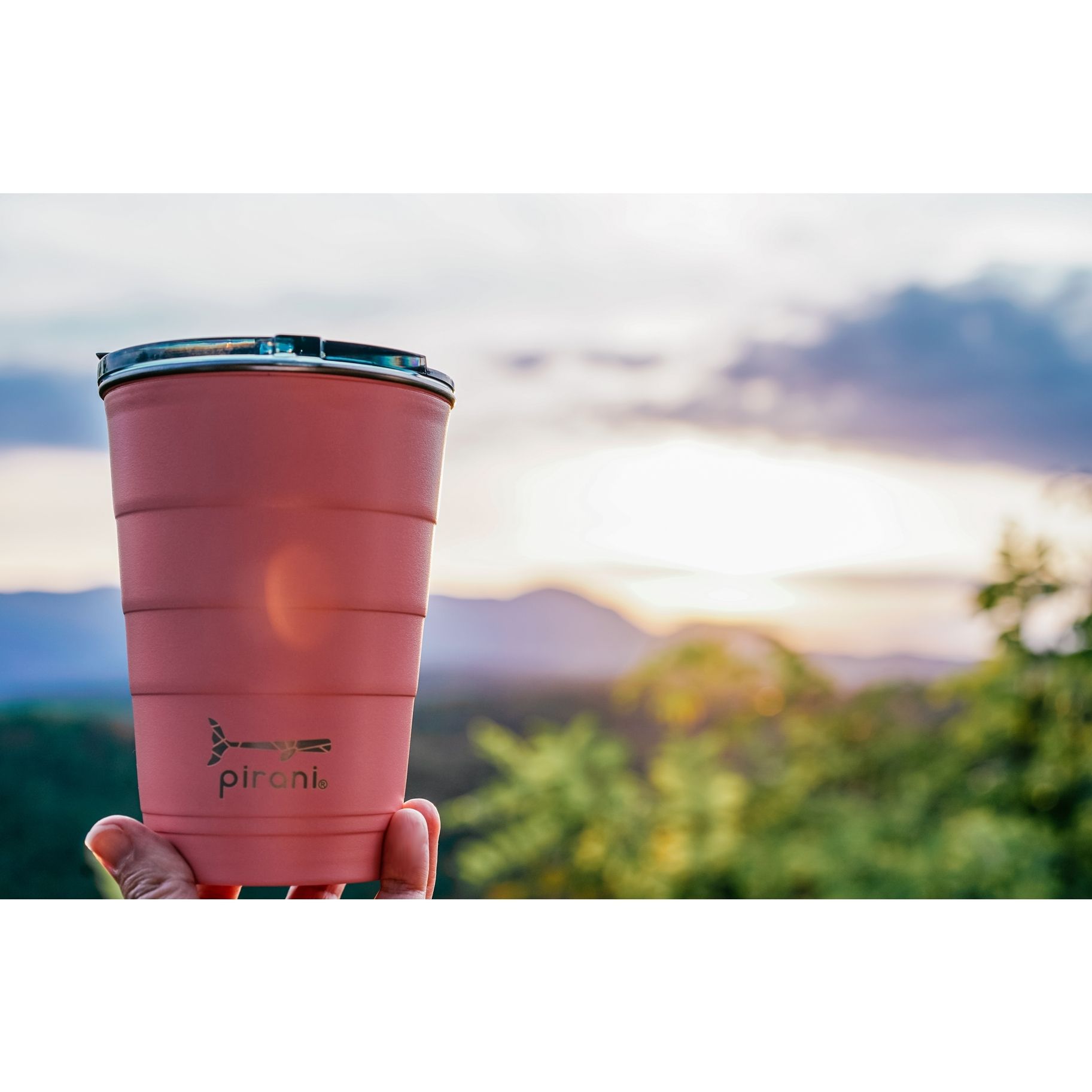 A person is holding a pink cup in their hand.