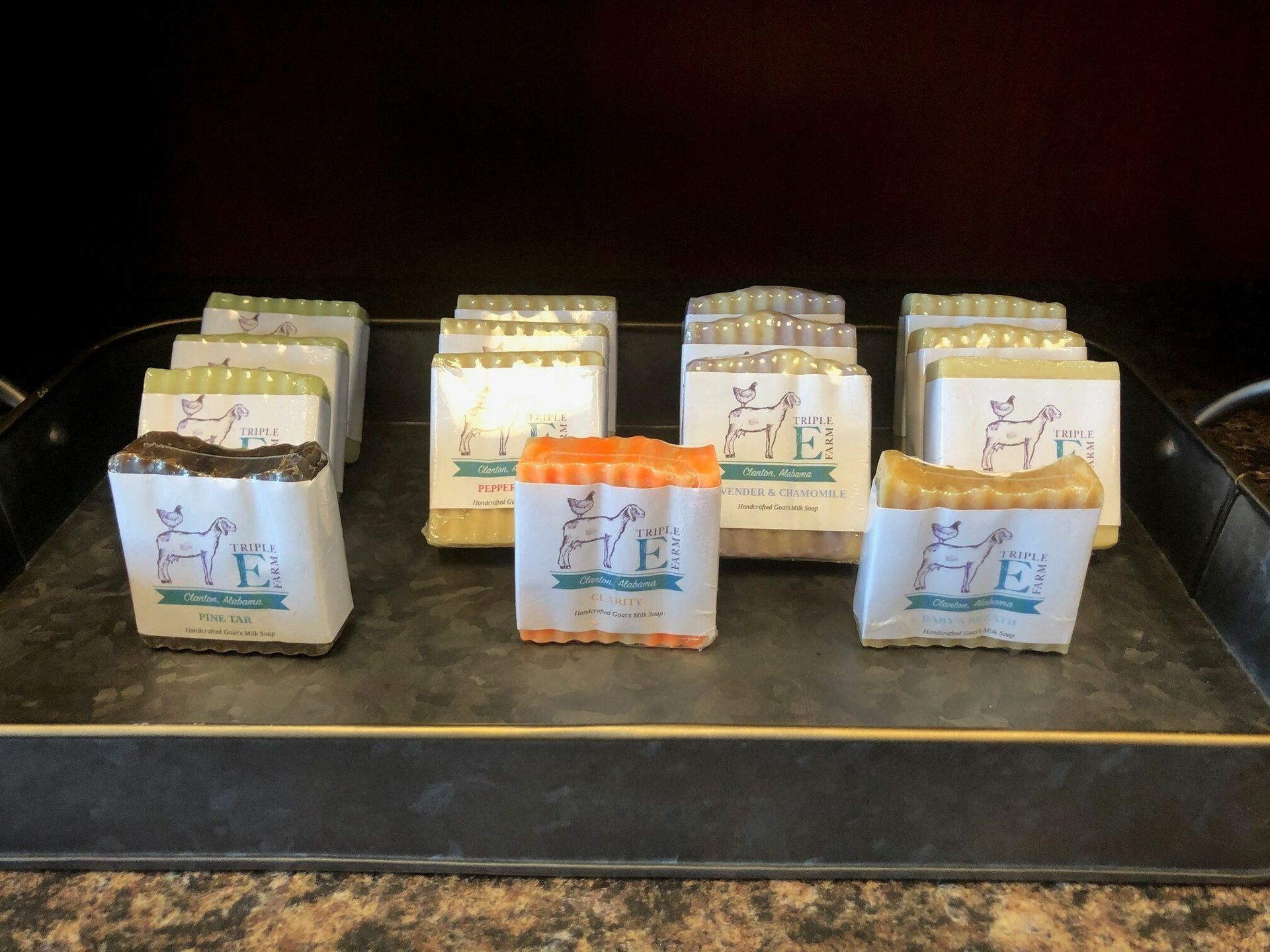 A bunch of soap bars are sitting on a tray on a counter.