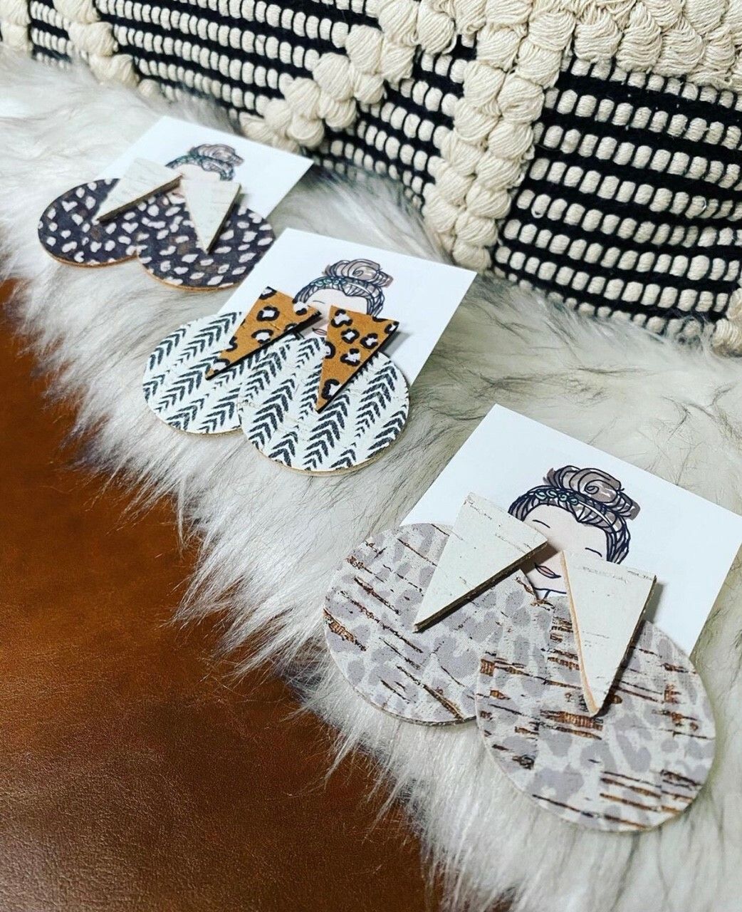 Three pairs of earrings are sitting on a furry surface.
