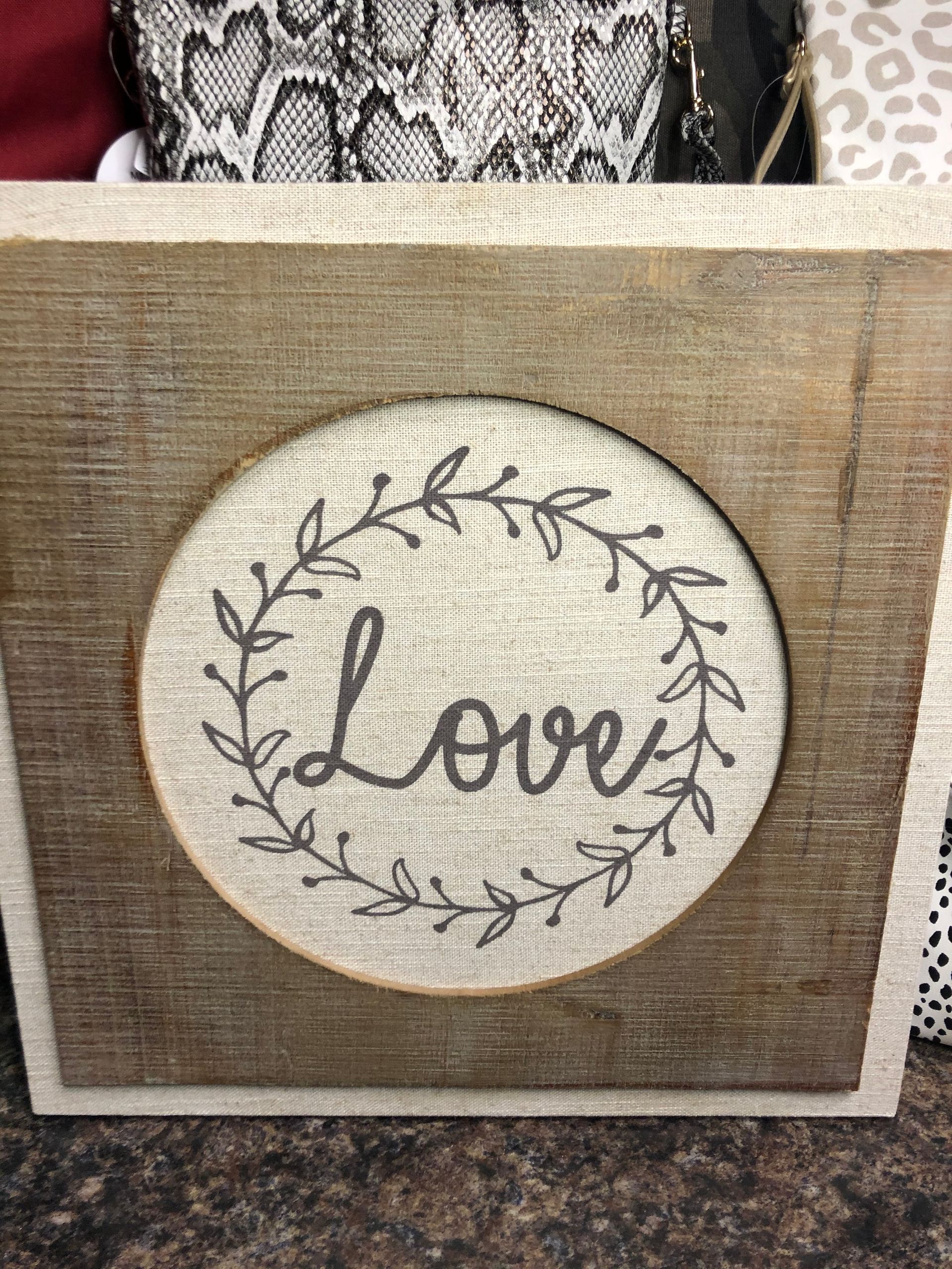 A wooden frame with a picture of a wreath and the word love on it.