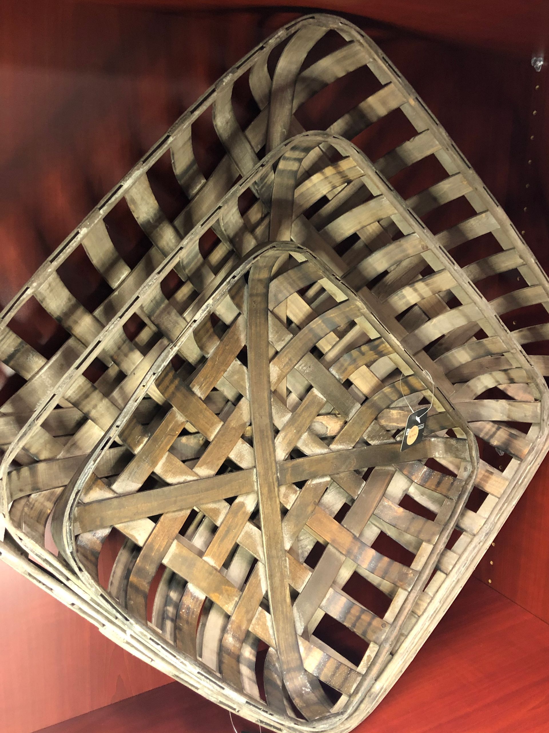 Three baskets are stacked on top of each other on a wooden table.