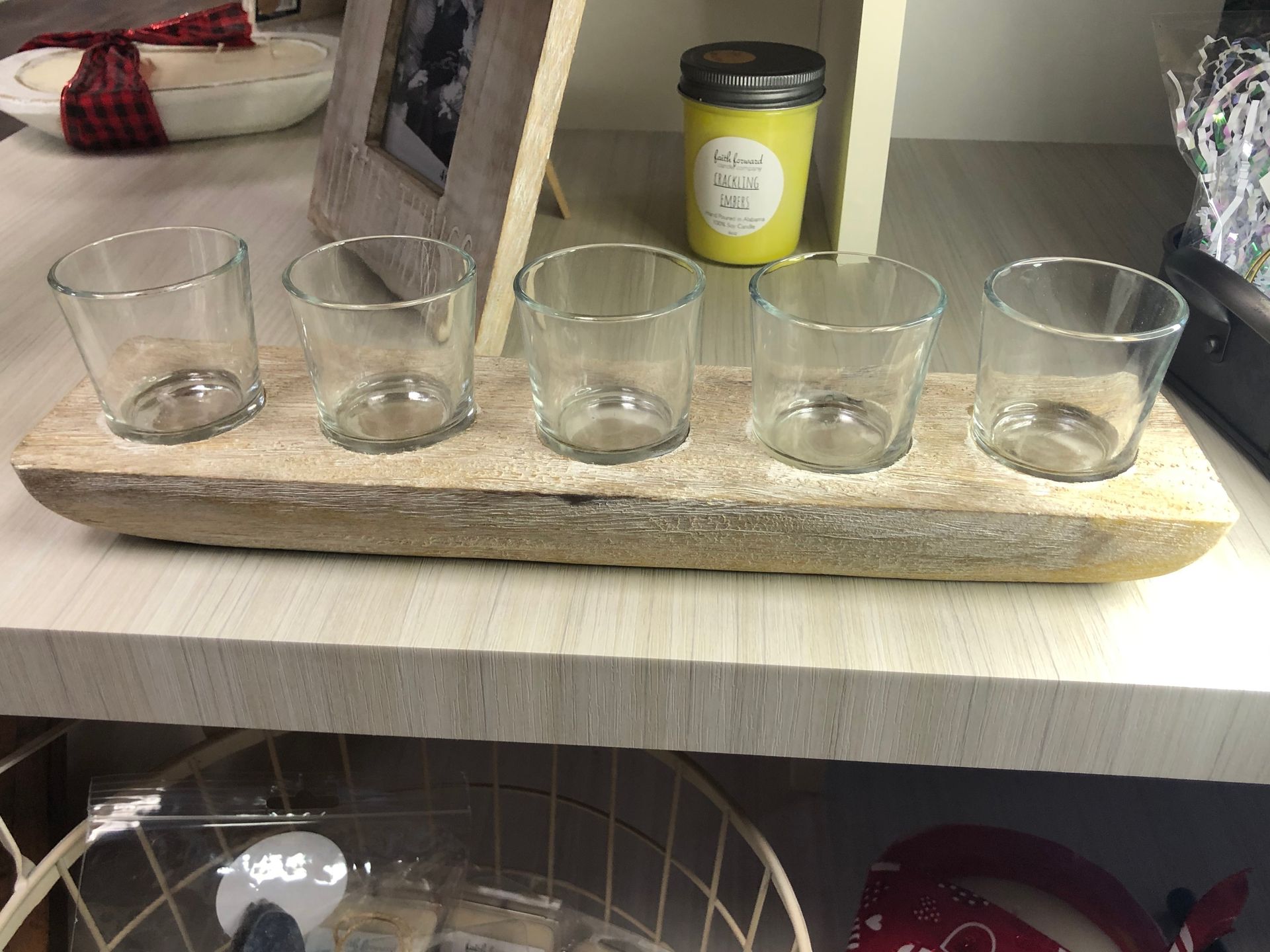 A wooden tray with four candle holders on it is on a table.
