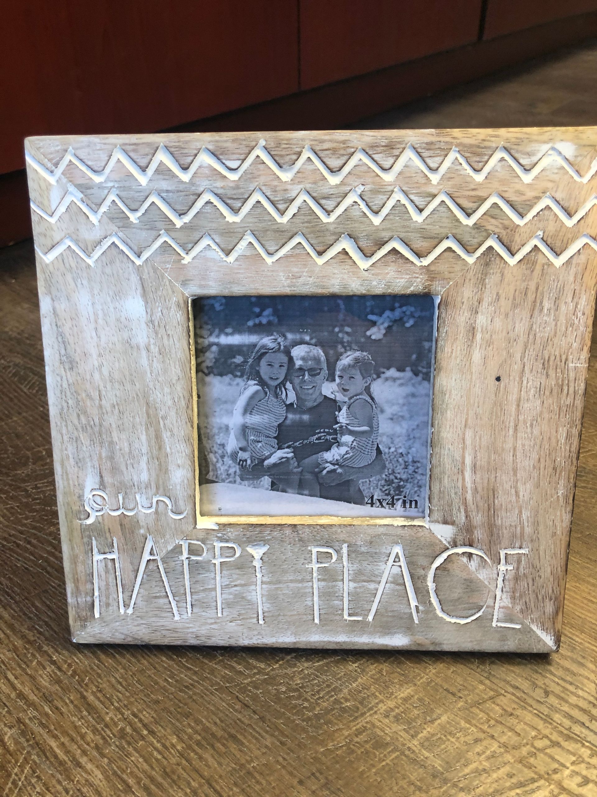 A picture frame with the words `` happy place '' written on it