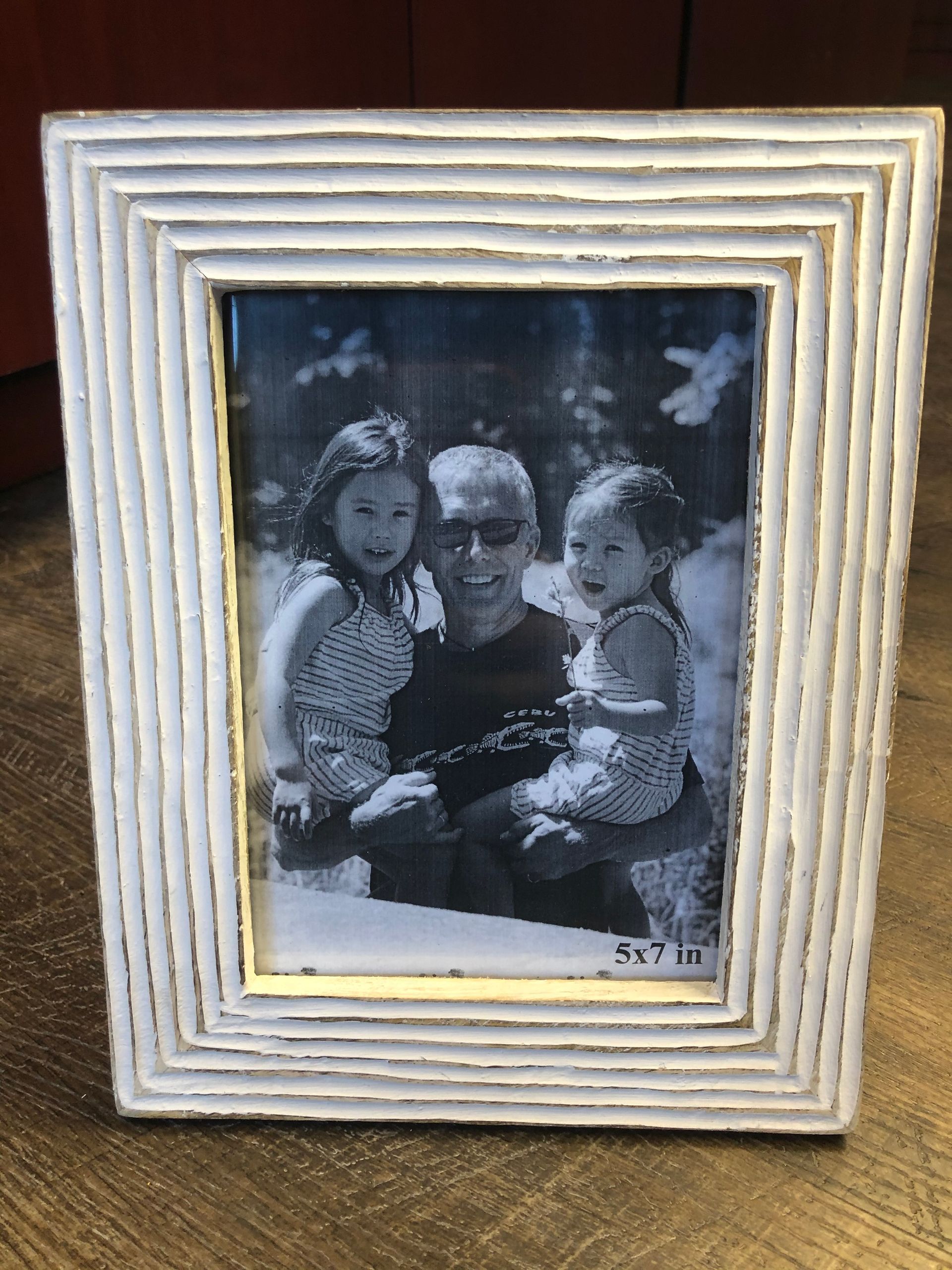 A black and white photo of a man and two children in a picture frame.