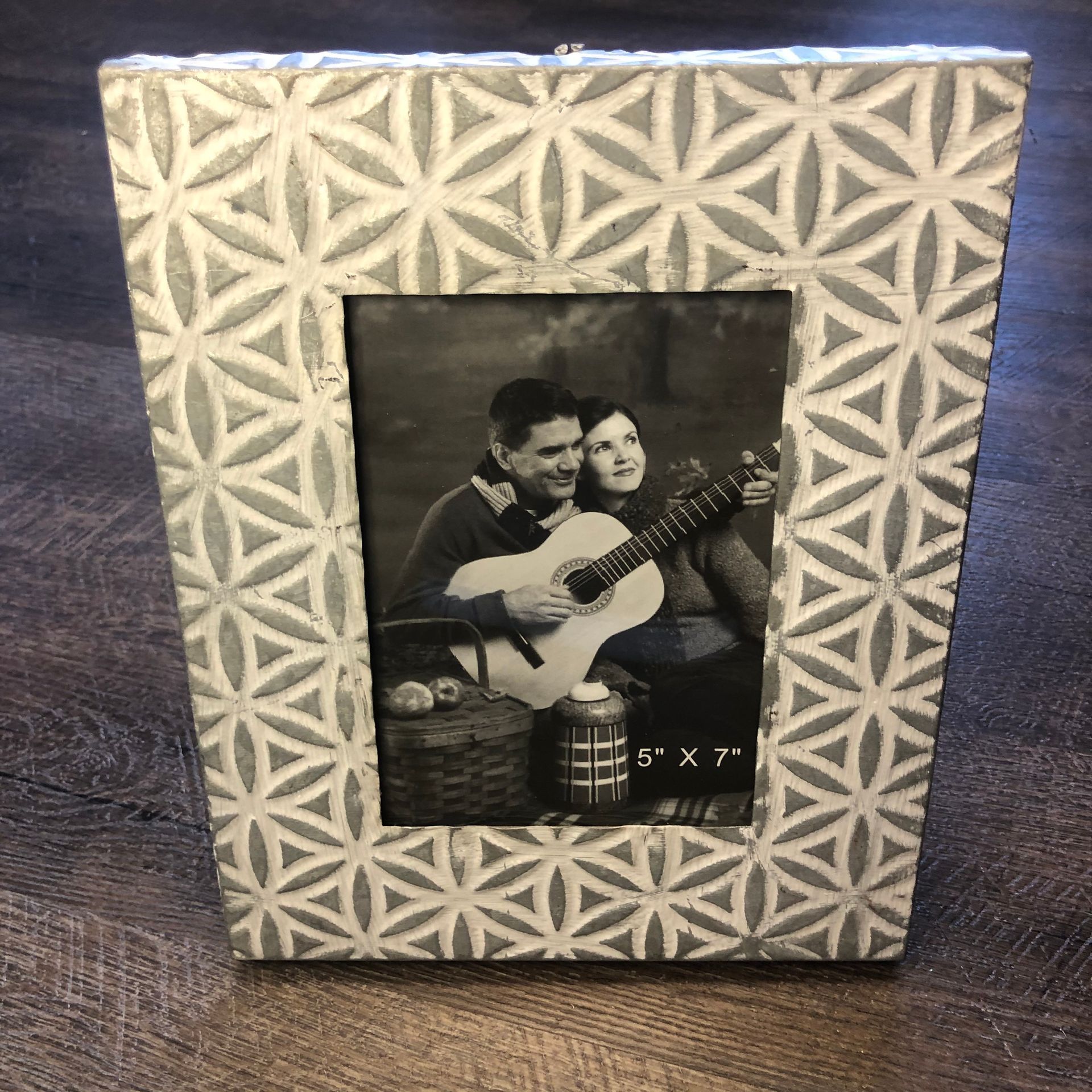 A picture frame with a picture of a man and woman holding a guitar