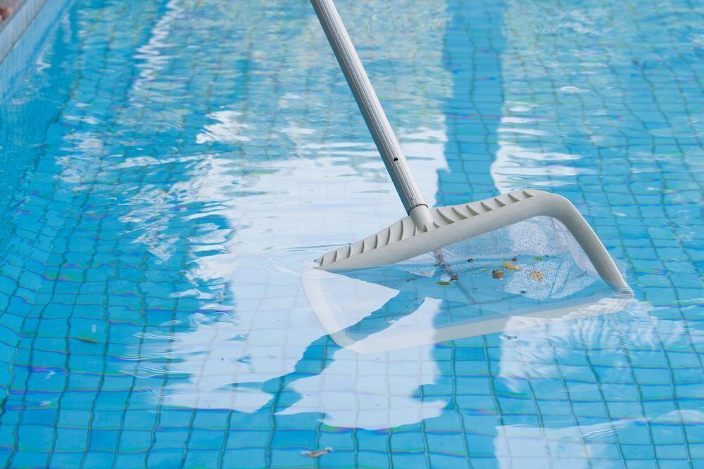 A Pool Cleaner is Being Used to Clean a Swimming Pool — Pool Maintenance in Pacific Heights, QLD