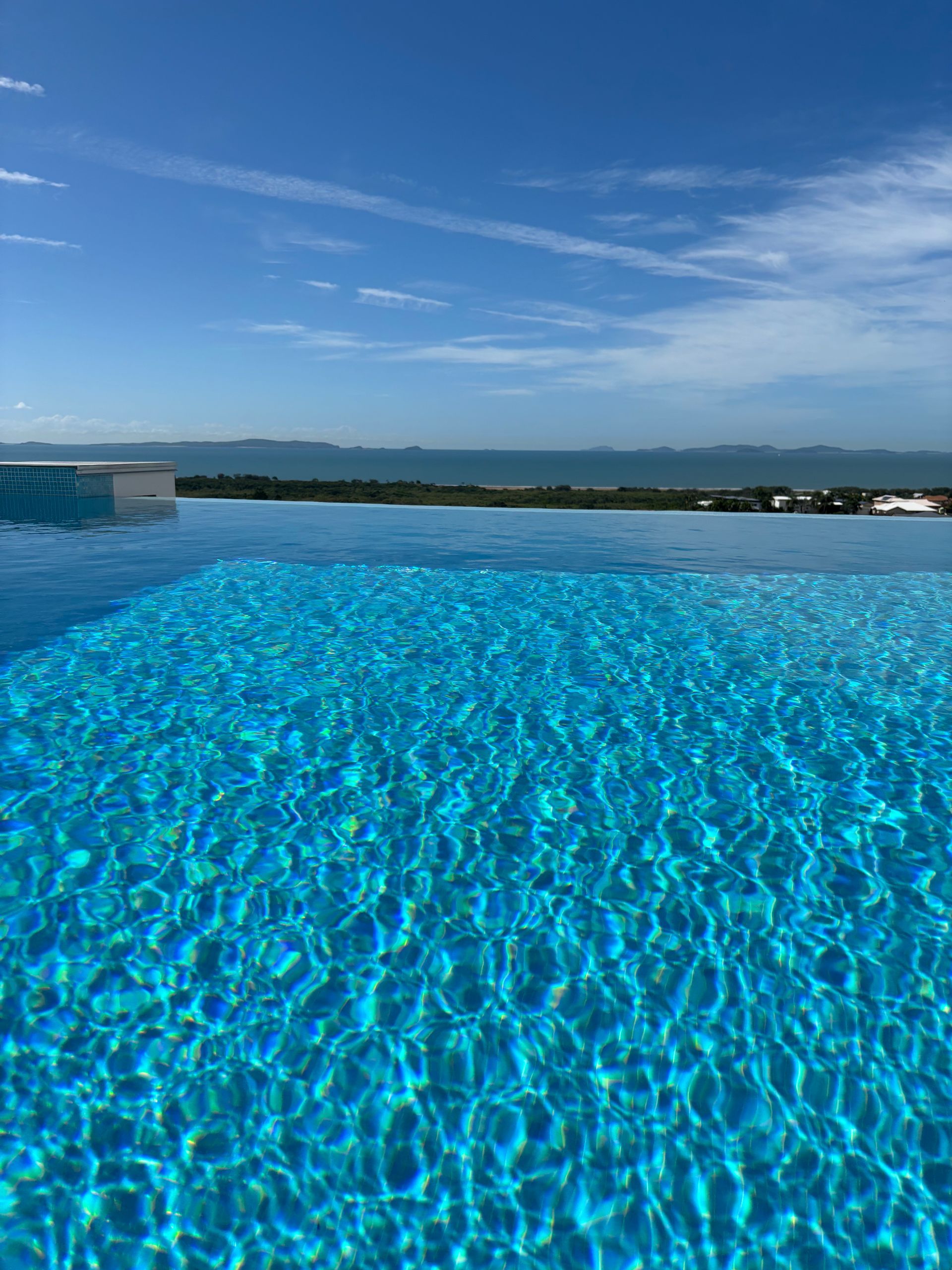 A Large Swimming Pool Surrounded by Trees and Chairs — Pool Maintenance in Pacific Heights, QLD