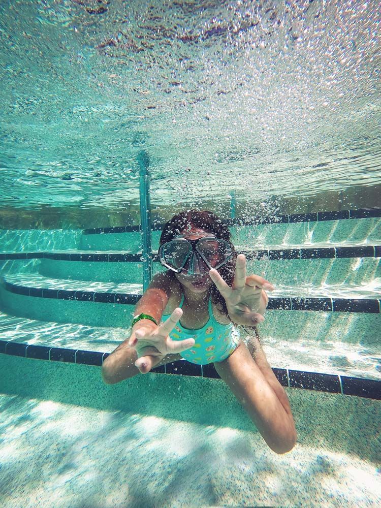 A Young Girl is Swimming Underwater in a Swimming Pool — Pool Maintenance in Pacific Heights, QLD