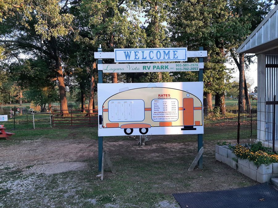 Sign for Laguna Vista RV Park; shows a cartoon trailer with a welcome message.