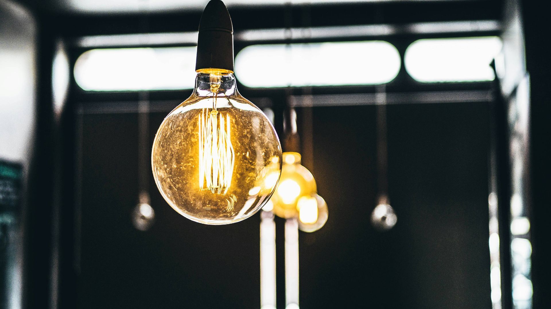 a close up of a light bulb hanging from the ceiling in a dark room
