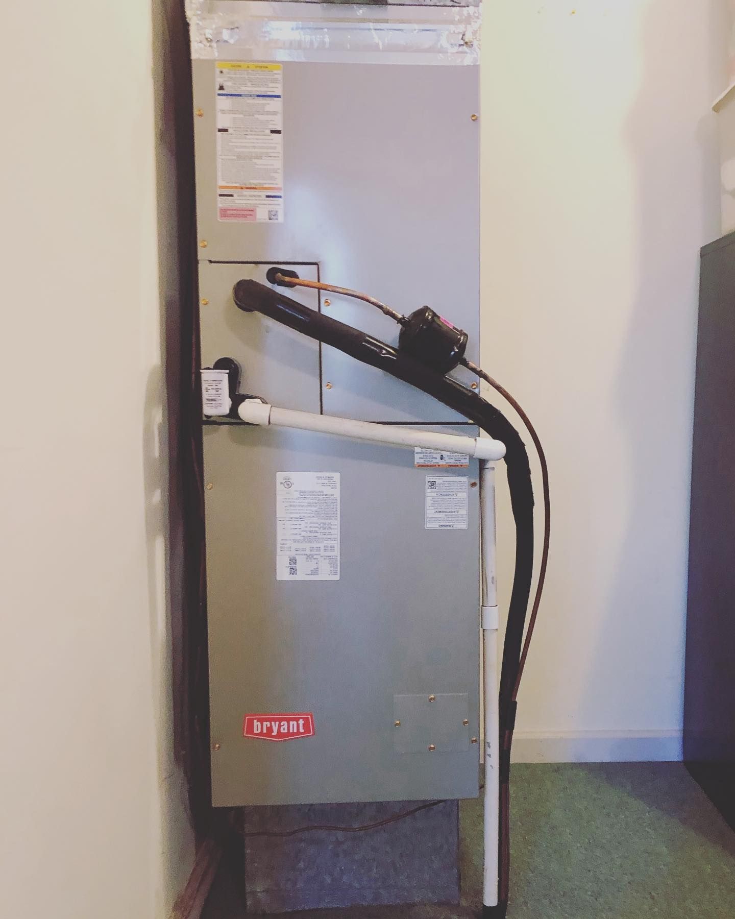 A lynx air conditioner is sitting in a room next to a wall.