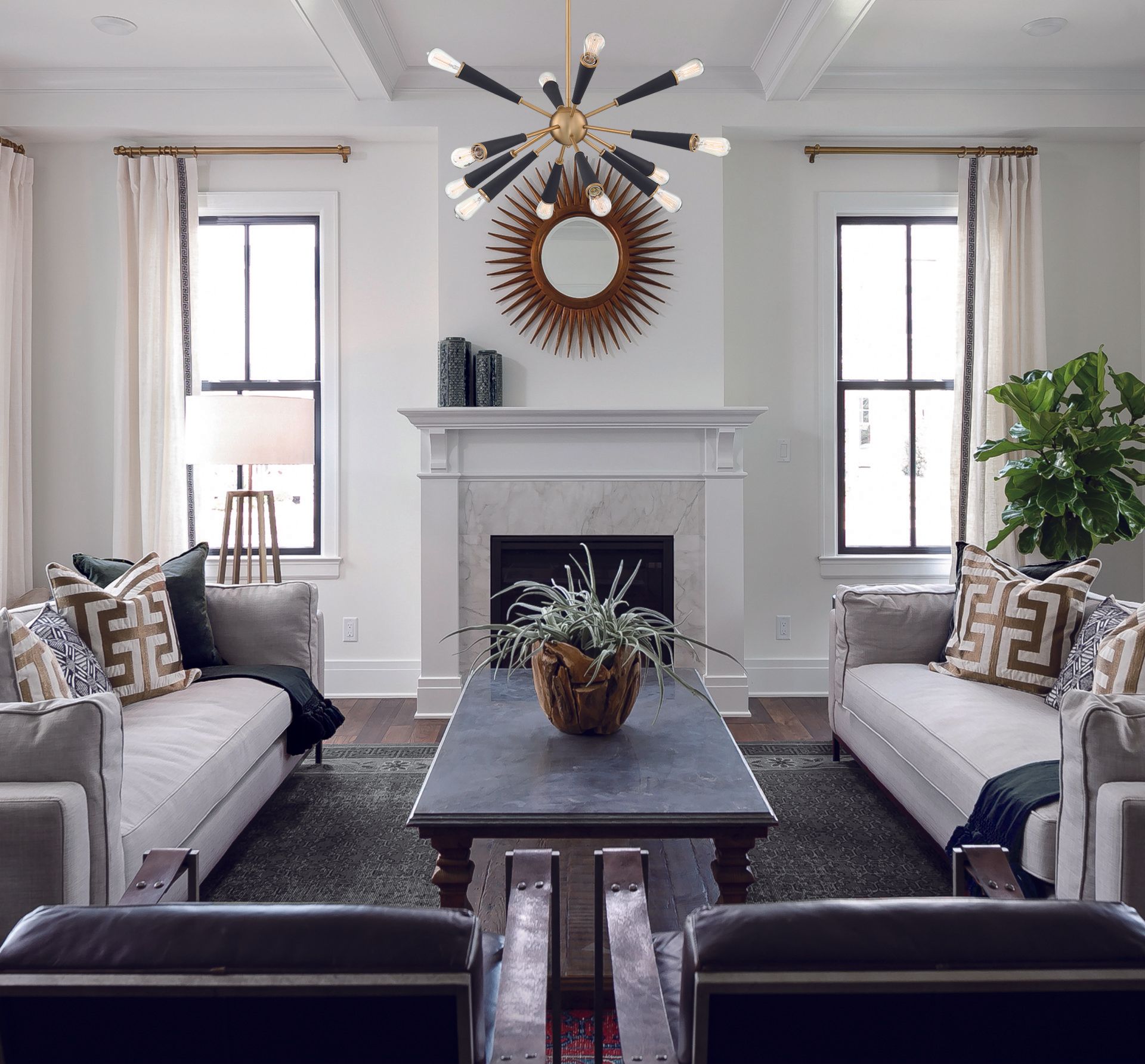 a living room with two couches and a fireplace with a mirror above it