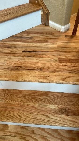 Wooden stairs with a landing and tan walls in a home interior
