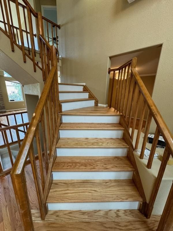 Indoor staircase with wooden railings and white steps in a home foyer
