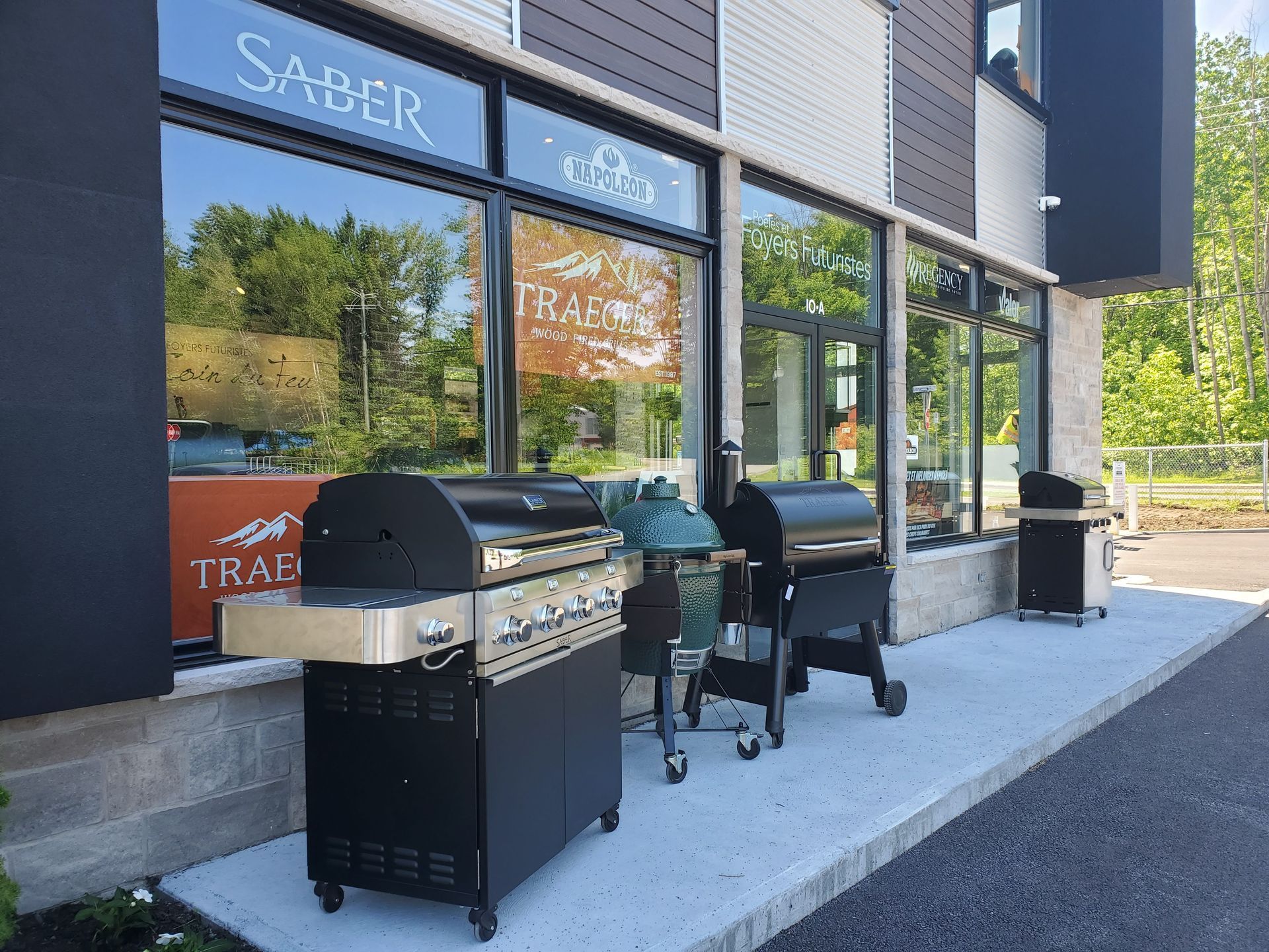 Grills displayed outside a store with large windows. The store's sign reads