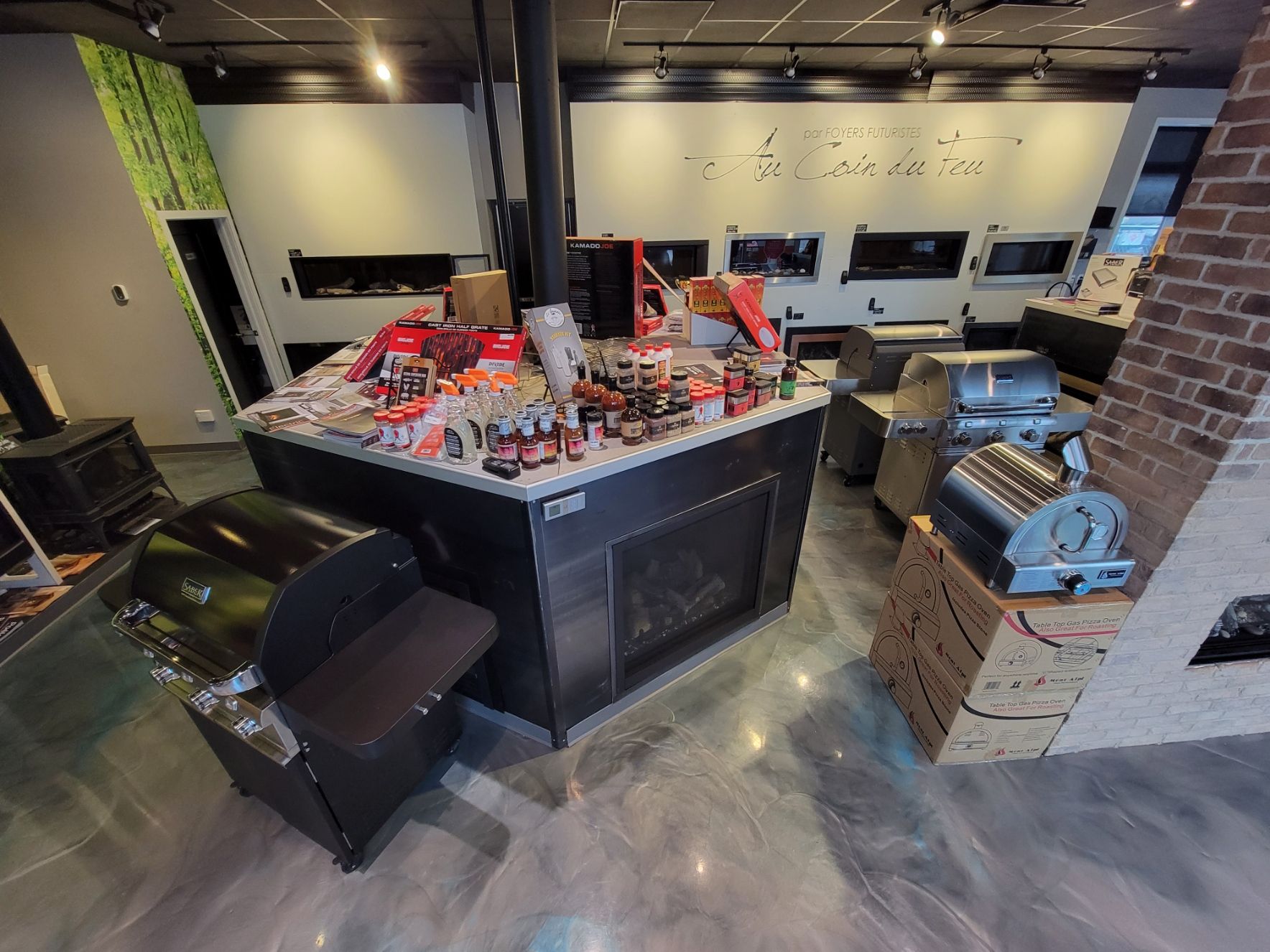 Indoor showroom with a variety of grills and firepits for sale.