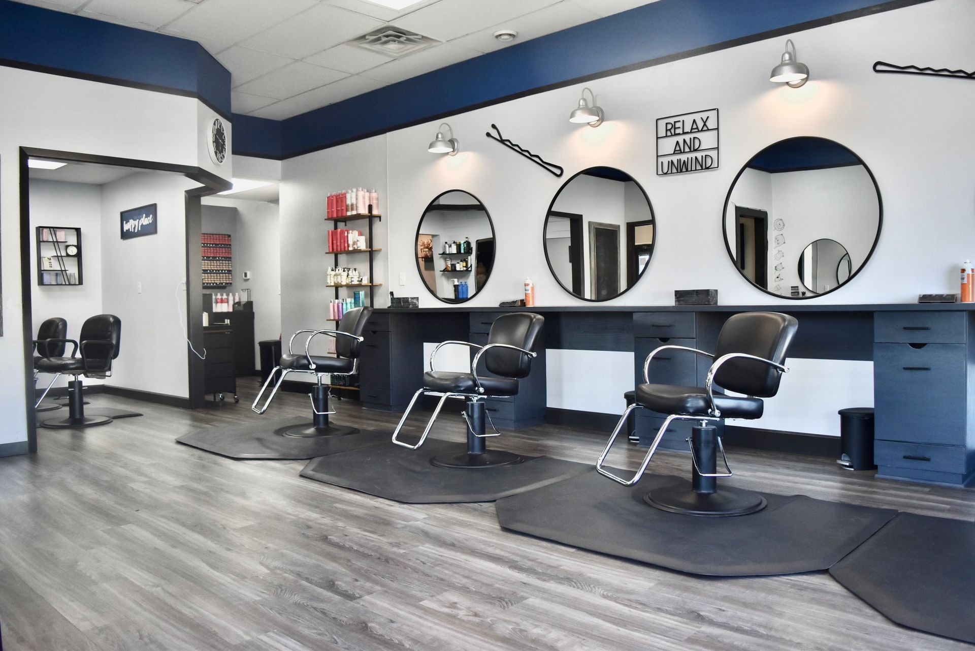 A hair salon with chairs and mirrors.