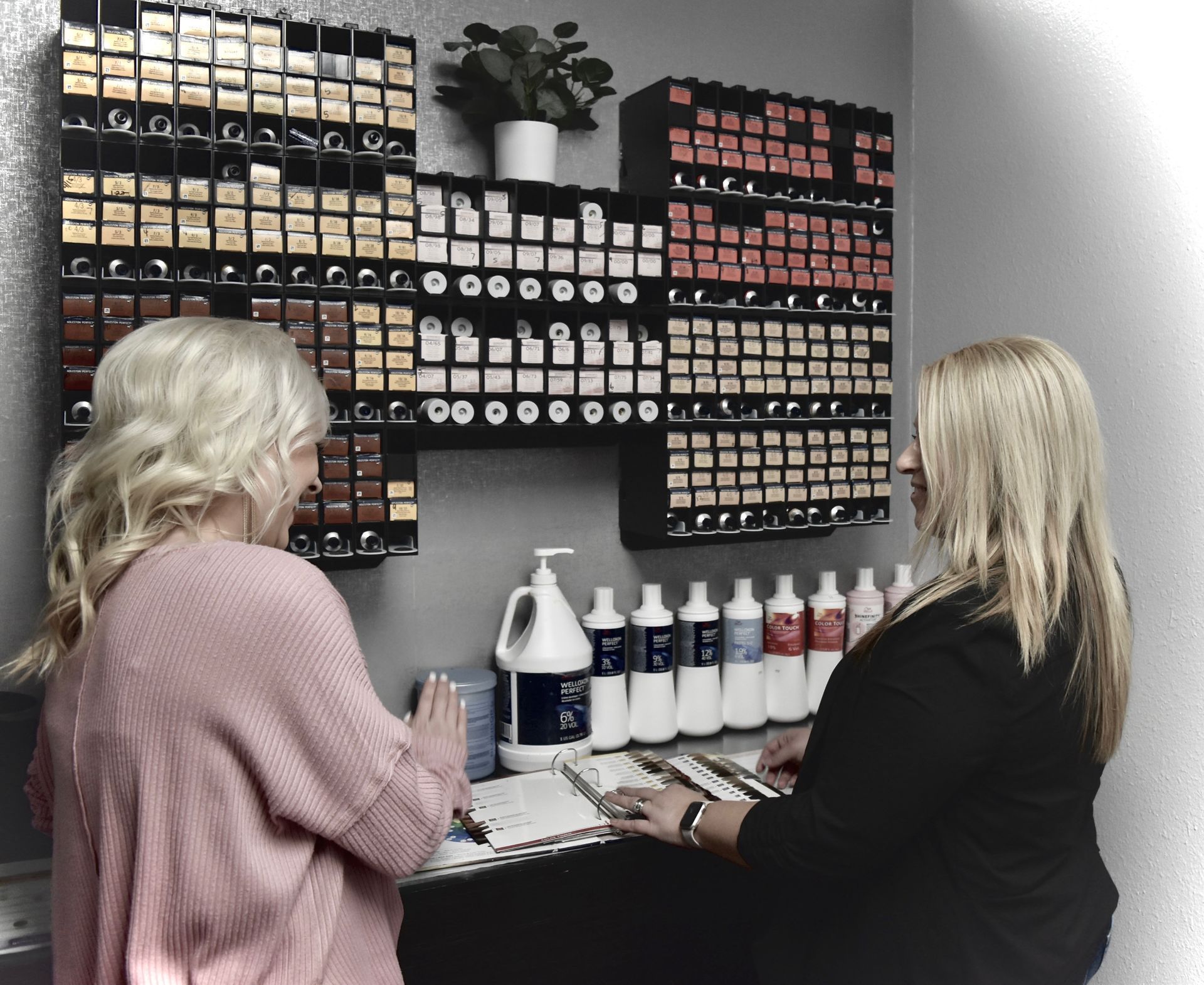 Two women are standing in front of shelves of hair dye