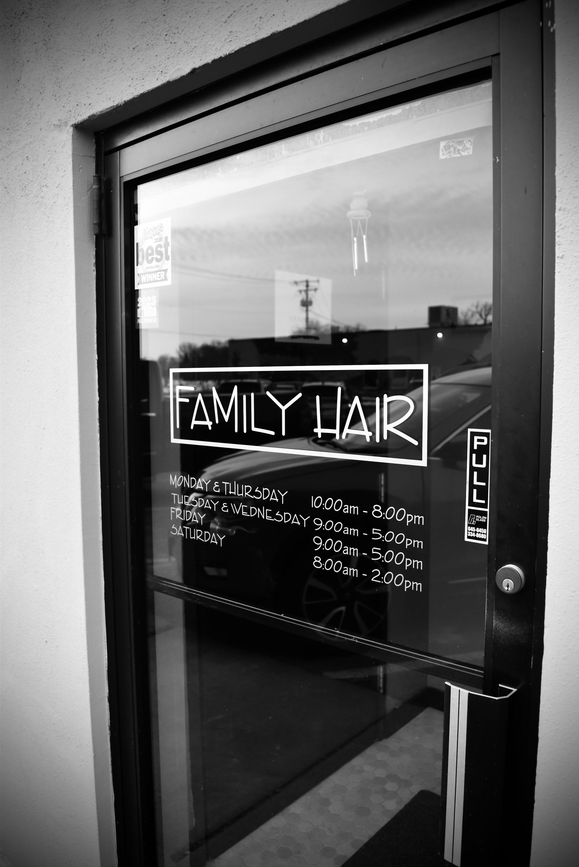 A black and white photo of a glass door that says family liar