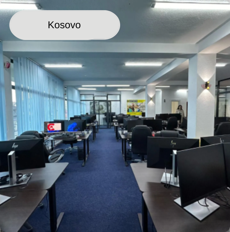 Bürointerieur im Kosovo mit Reihen von Computern und Schreibtischen, Angestellte bei der Arbeit.