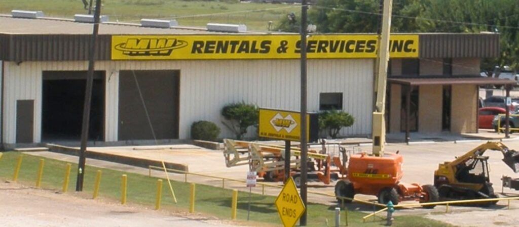 A building with a yellow sign that says rentals & services inc.