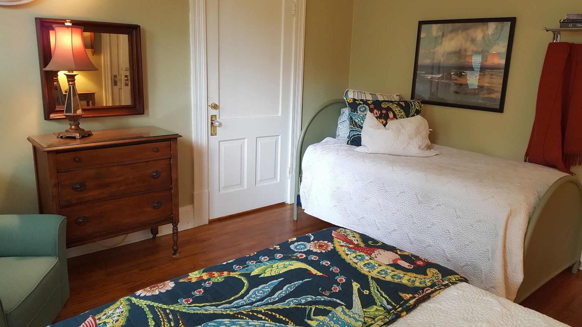 A bedroom with two beds and a dresser