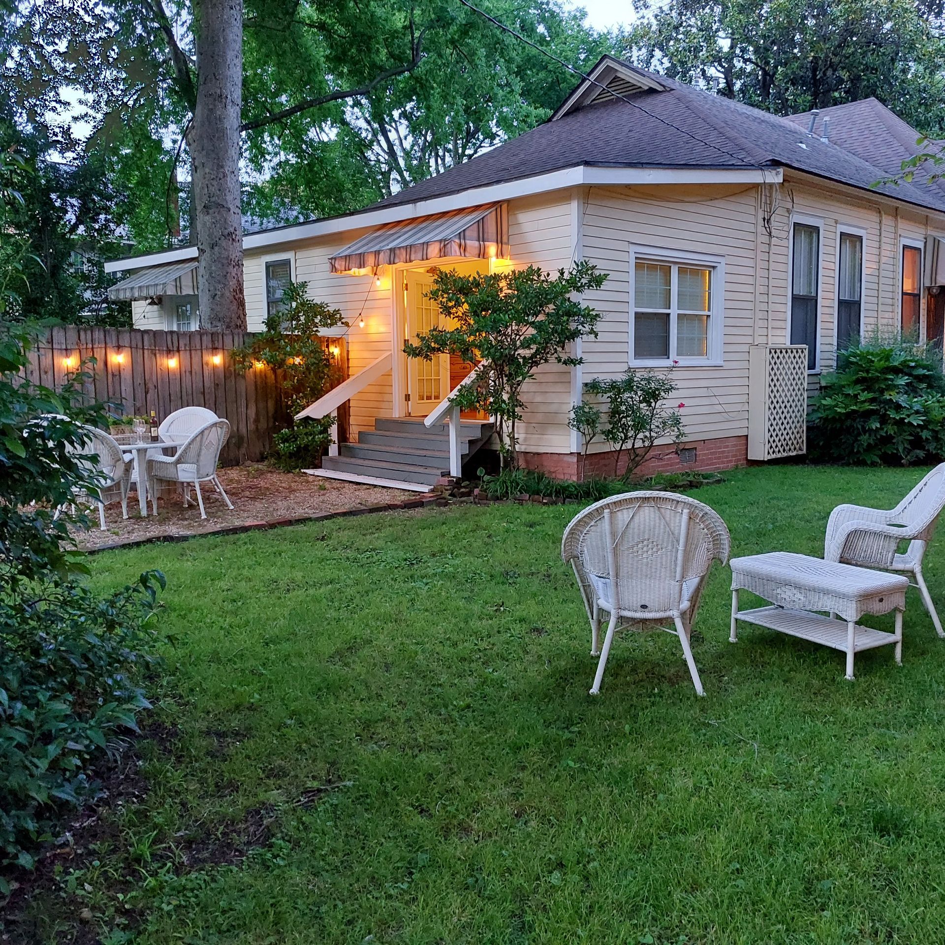 A house with a fence and chairs in front of it
