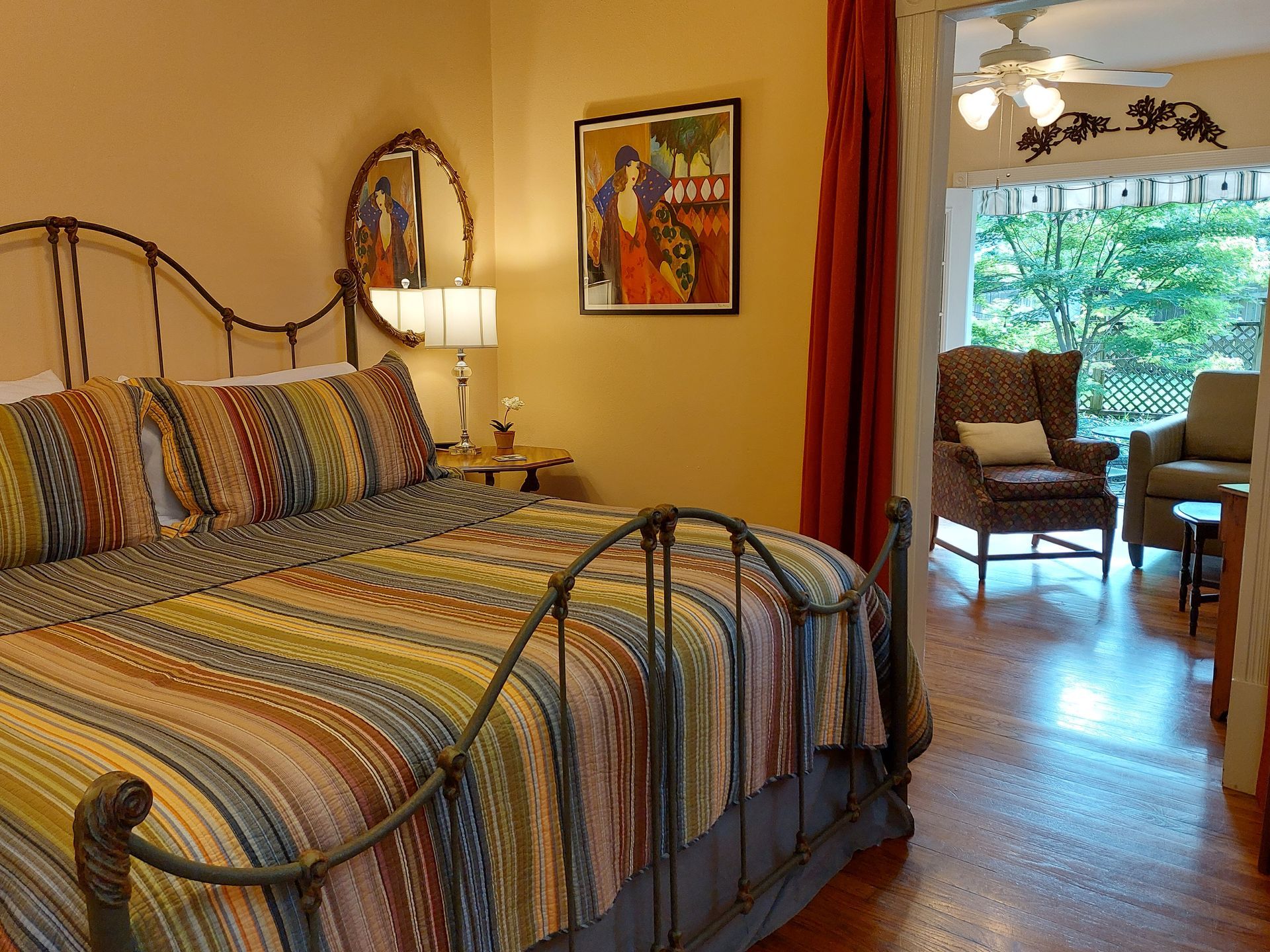 A bedroom with a large bed and a painting on the wall