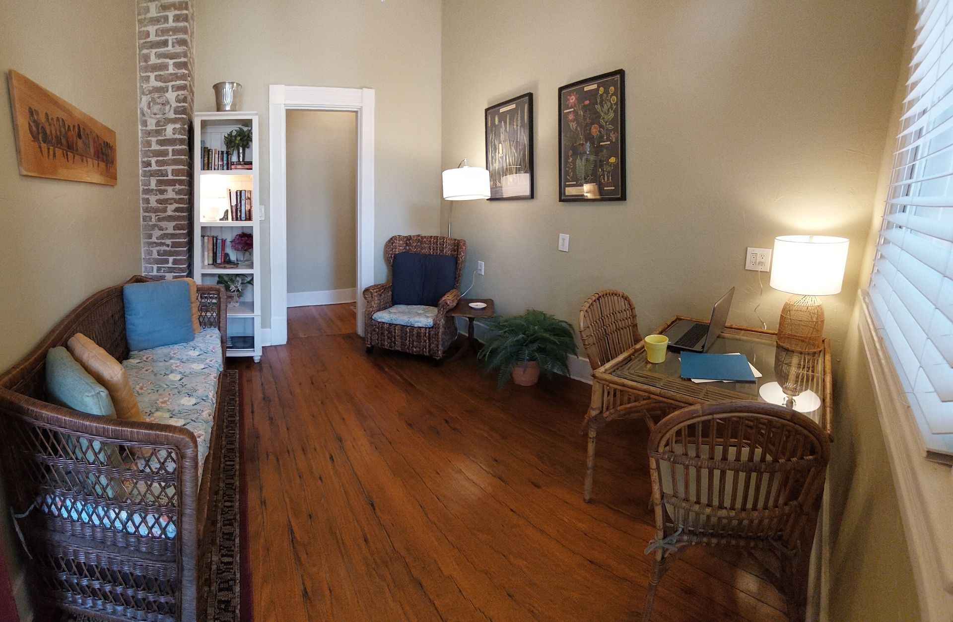 A living room with wooden floors and wicker furniture
