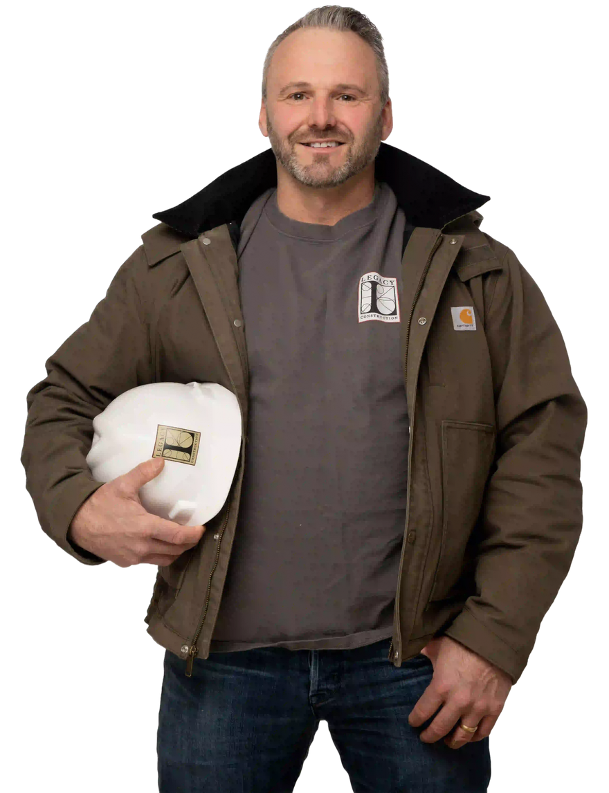Smiling man in brown jacket holding a white hard hat, standing against a white background