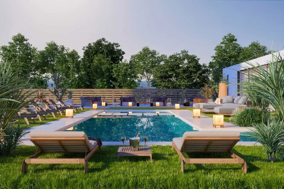Backyard pool with lounge chairs, green lawn, and stone patio at sunset